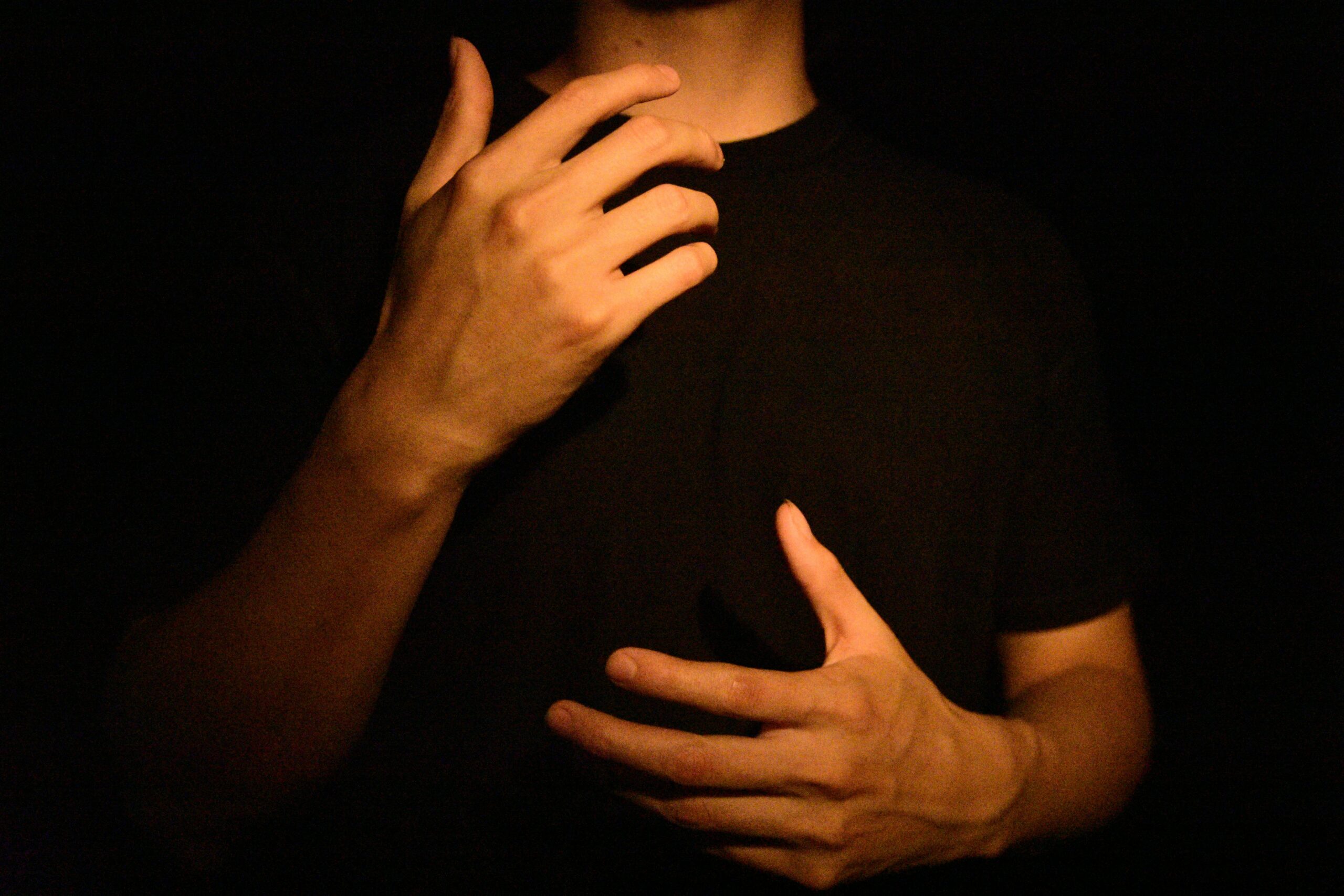 Person exploring body awareness through hand gestures during IFS therapy