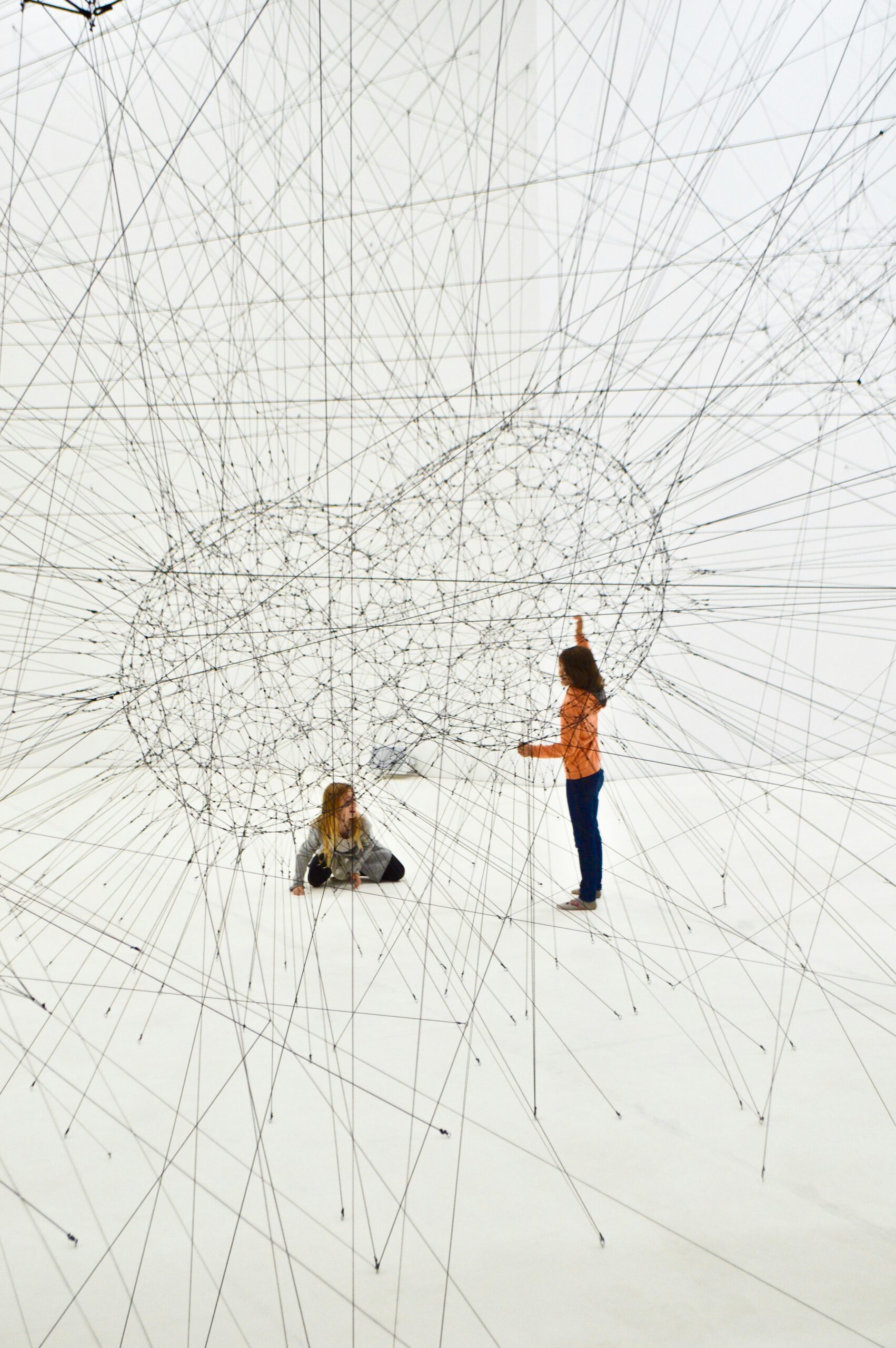 Two people standing inside an intricate web of strings symbolizing complex trauma and nervous system entanglement.
