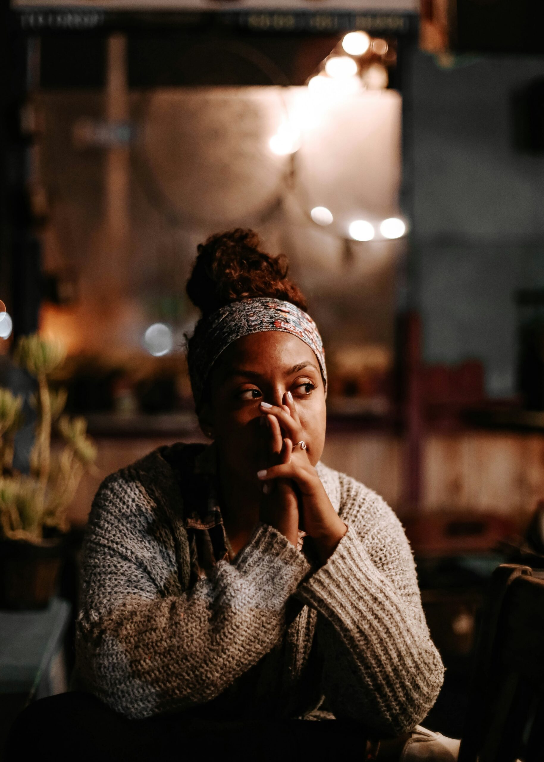 Woman sitting reflectively in a therapy setting representing the difference between somatic therapy and CBT approaches to emotional healing in NYC.